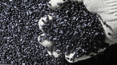 塑料黑灰色颗粒状的碎屑。生产塑料水管的工厂。用水和空气的压力在机床上制造塑料管的工艺。