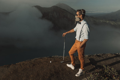 戴着防护面具的游客站在火山峭壁前