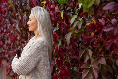 Young beautiful woman in sweater, stands with book