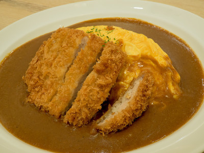 咖喱饭，脆猪肉片和煎蛋卷放在木桌上