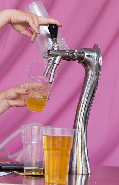 酒保把啤酒倒进塑料玻璃杯