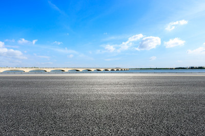 蓝天下的柏油路和湖桥