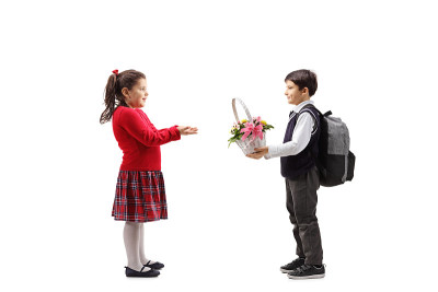 一个男生把一个花篮送给一个小女孩