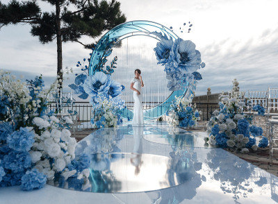 快乐的新娘穿着白色的婚纱在装饰精美的宴会厅外面