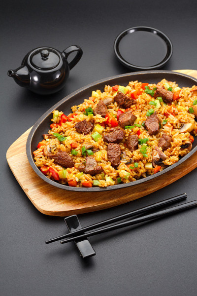 日本料理。米饭和小牛肉在黑色的背景。