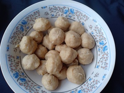 黑色背景下白碗里的牛肉丸子