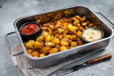 Patatas bravas是一种传统的西班牙土豆小吃，放在钢托盘里。灰色的背景。俯视图