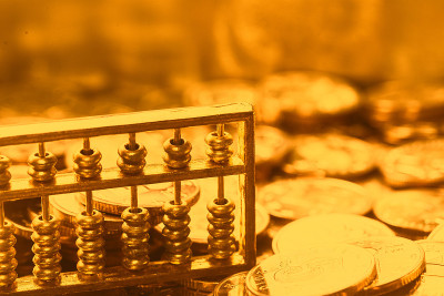 一个金算盘放在一堆金币的背景上
