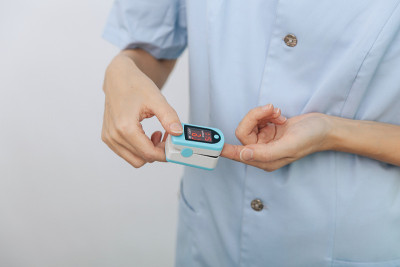 脉搏血氧仪用医生的手隔离在白色上。便携式数字仪器的概念来测量人的氧饱和度。测量氧饱和度，脉搏率和氧含