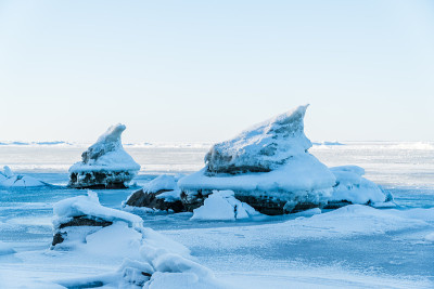 在波罗的海的海滩上，冰雪覆盖的巨石和岩石破冰而出
