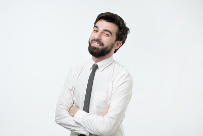 微笑英俊的西班牙男子在白衬衫交叉双手。