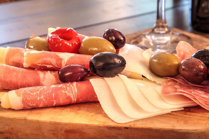 Charcuterie board on rustic wood with candles behi