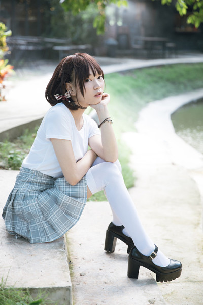 亚洲女孩的肖像与白色衬衫和裙子坐在户外自然复古电影风格