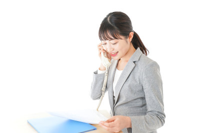 年轻的女商人在办公室使用商务电话