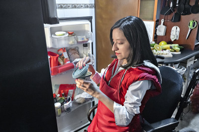 残疾拉丁美洲妇女在冰箱里寻找食物