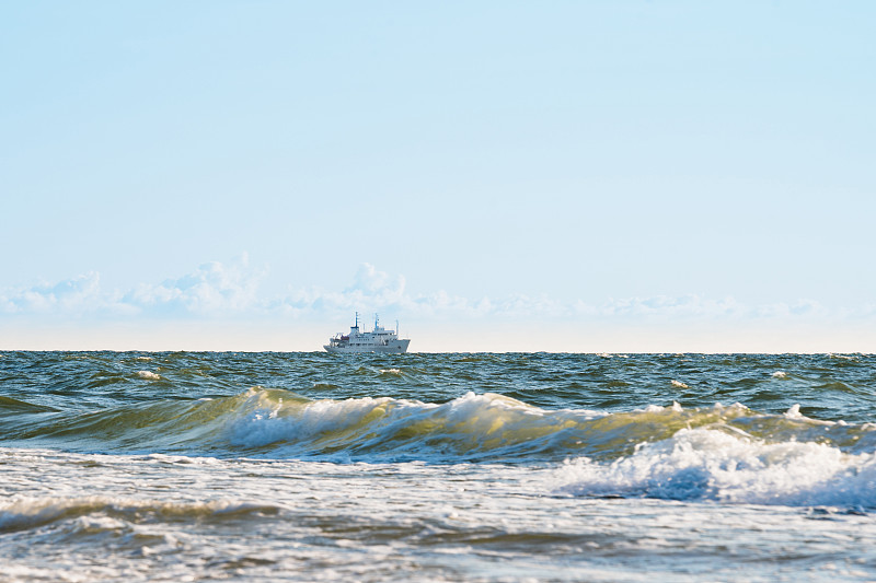 这艘船在海岸附近波涛汹涌的海面上航行