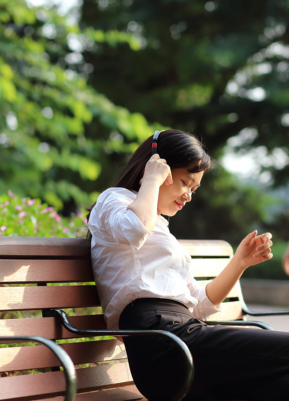 一名年轻女子在河内用智能手机听音乐