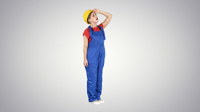 戴着黄色头盔的女工程师惊讶地抬头看着一座建筑