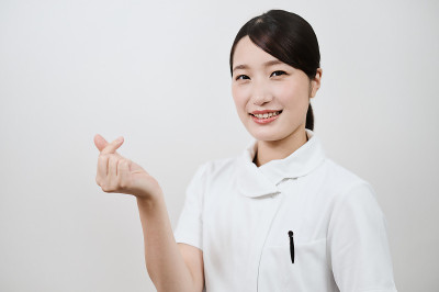 一个穿白大褂的女人在做心形记号