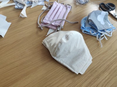 Self-sewing防护面具。桌上放自制的防护口罩和几块布