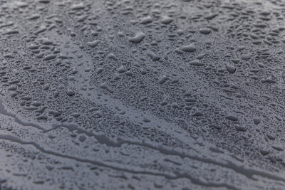 雨滴落在黑色的汽车引擎盖上
