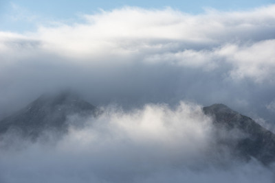 这是一幅引人注目的景观图片，从Derwentwater湖区望向Catbells雪山，浓雾在山谷中翻滚