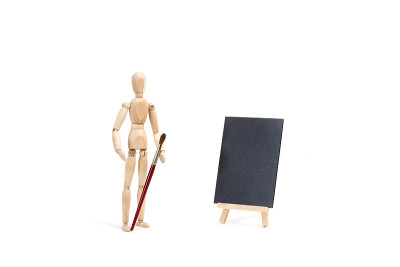 手里拿着画笔的木制人偶玩具