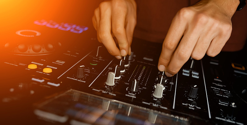 男子扭在夜总会的DJ控制器的声音