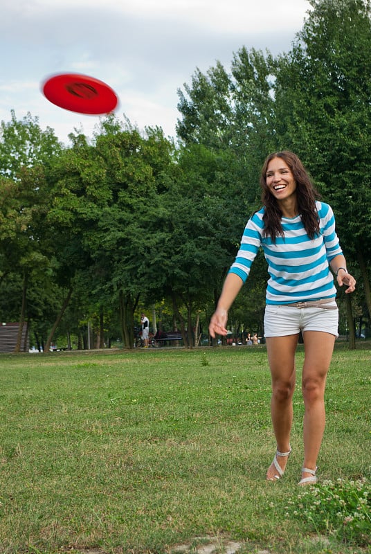 年轻女子在户外玩飞盘