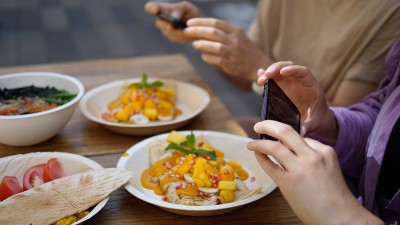 两名女性正在用智能手机拍摄她们的素食午餐。健康的素食生活方式概念