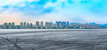 日落时分空旷的柏油路和重庆的城市天际线