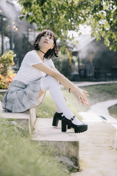 亚洲女孩的肖像与白色衬衫和裙子在户外看自然复古电影风格