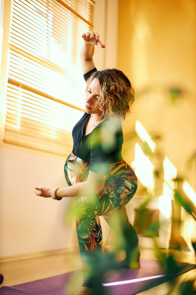 Middle aged flexible pregnant yogi woman standing 