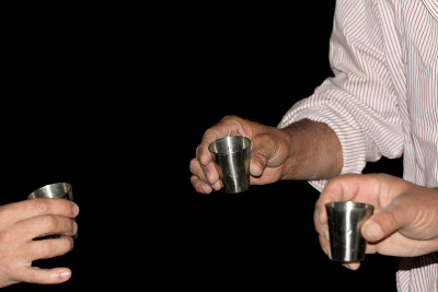 黑色背景上，手里拿着三只酒杯