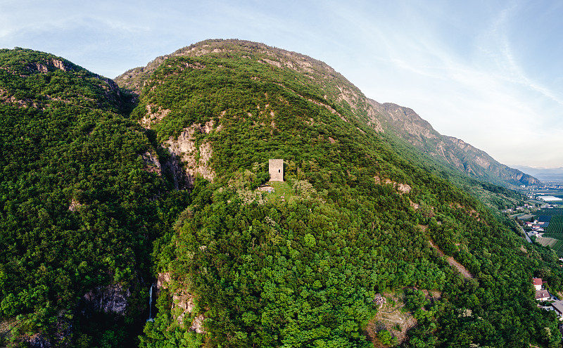 古老的石塔中间有一座大山，四周是森林