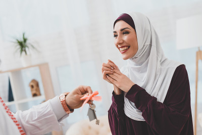 在kufiya的阿拉伯人给迷人的阿拉伯女人戴着头巾的公寓钥匙。