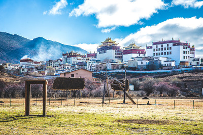 牧场上的木门俯瞰甘丹寺在云南香格里拉
