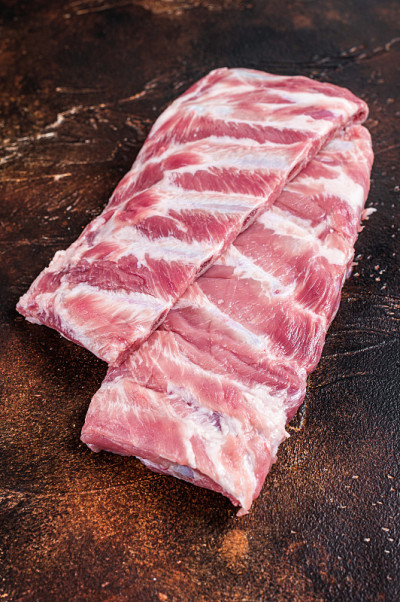 肉铺桌上的生排骨。黑暗的背景。俯视图