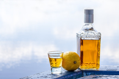 湖边的瓶装龙舌兰酒和柠檬杯