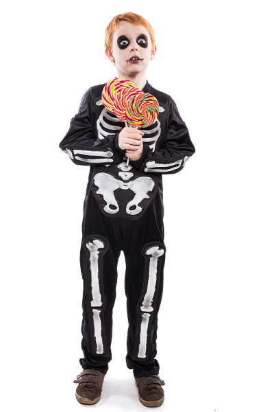 小男孩穿着万圣节服装，拿着五颜六色的糖果