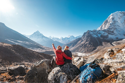 一对夫妇正在Dughla 4620m附近的珠峰大本营徒步旅行路线上休息。背包客离开背包和登山杆，在海