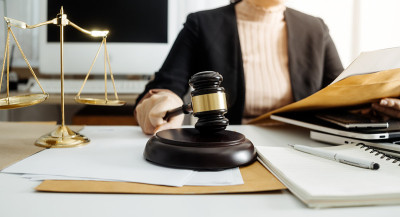 商务和律师在办公室桌上用黄铜秤讨论合同文件。法律、法律服务、法律咨询、司法和法律概念的画面具有电影纹