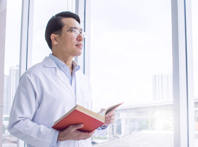 亚洲医生在窗边读书学习