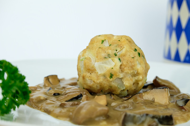 自制的巴伐利亚面包饺子，在德国南部被称为Semmelknödel，在野生蘑菇奶油肉汁上，海湾bole