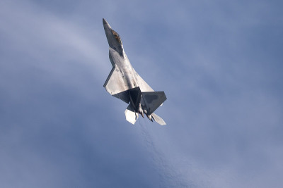 F-22猛禽在美丽的光与云，与喷射流可见飞机后面