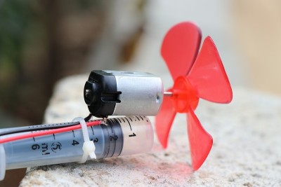 直流电动机与塑料螺旋桨附在其轴和注射器的伸缩运动