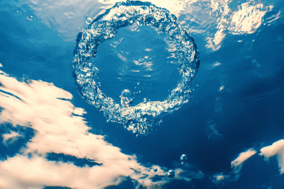水下的气泡环向太阳升起。