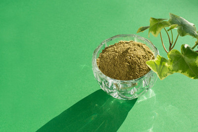 抹茶干的绿色粉末在粉红色的背景上制作日本天然茶