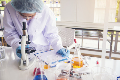 特写女科学家手用滴管在实验室看科学显微镜医学试验，研究生物化学。女性技术员实验室分析血液科学药物研究