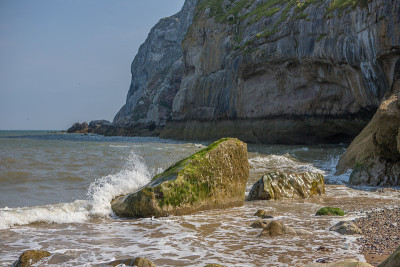 海浪拍打着小奥姆的岩石，Llandudno。北威尔士卵石滩